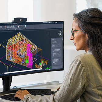 Person working on a computer displaying a 3D house model in CAD software.