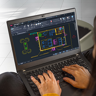 person using a laptop displaying a detailed architectural floor plan in CAD software.
